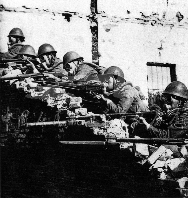 在淞沪作战中，日军施放毒气后，戴着防毒面具与中国军队作战。