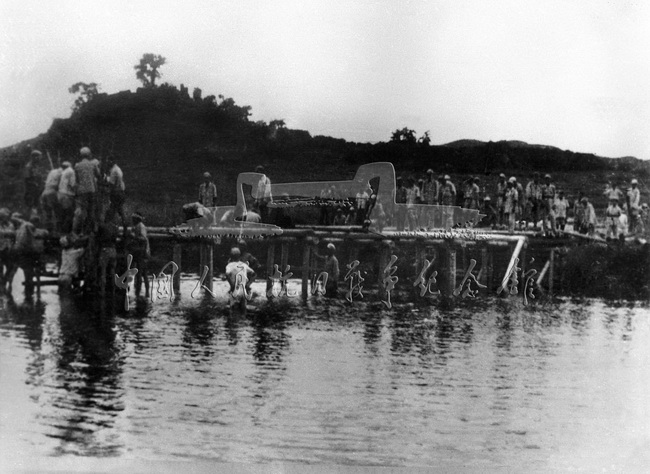 东江纵队向广九路和潮汕进军，收复国土。图为部队在进军中架设桥梁。