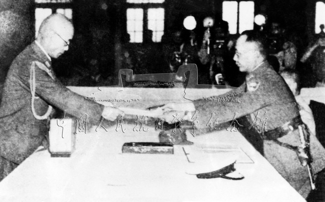 日本中国派遣军总参谋长小林浅三郎向中国国民政府军事委员会参谋总长何应钦呈递投降书。
