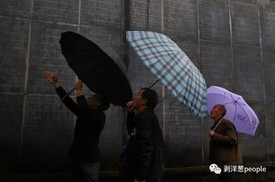 张三幸与儿子张立、朋友在中国远征军名录墙上寻找父亲张双照的名字。