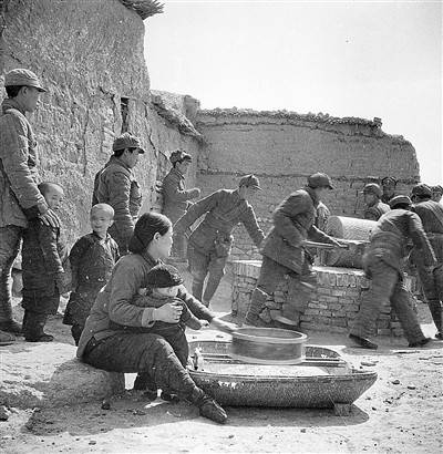 1945年冬，冀中三纵队的战士们在怀来县帮助群众推碾子。