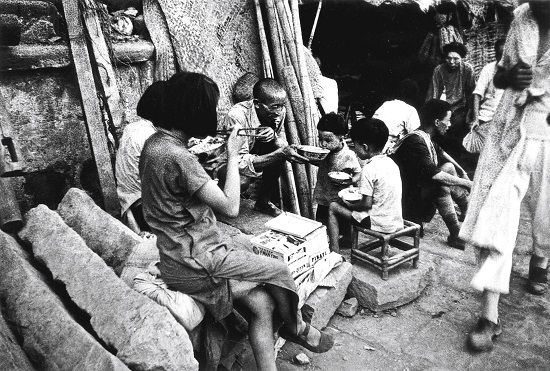 1940年8月，在日军飞机轰炸过后，重庆一家人赶忙吃口饭