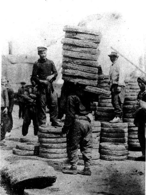 06 搬运豆饼的劳工。每片豆饼约23公斤，一般每个劳工每次至少要扛4至6片，重达100多公斤。