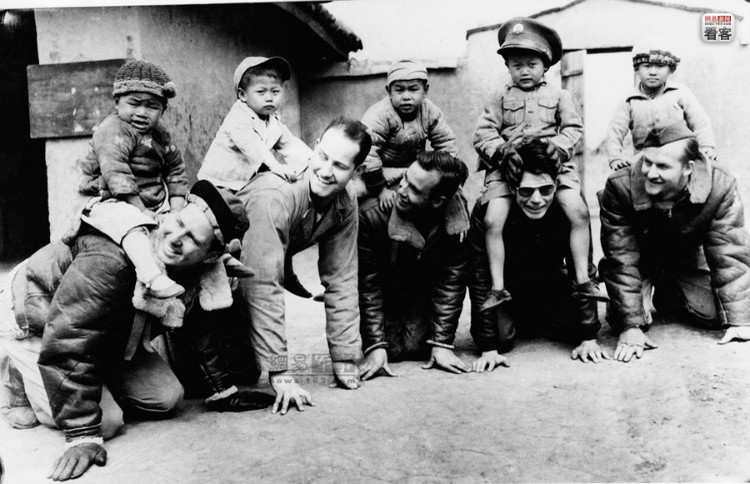 1943年4月12日，一群美国空军的士兵在和一群孤儿玩骑大马的游戏。从左起分别是斯美特中尉，怀特军士，布兰宁军士，威廉
