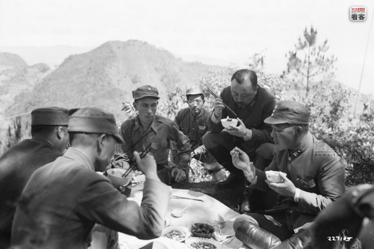 1944年6月4日，在怒江前线惠通桥上方的永阔山，中国远征军司令卫立煌上将（没有戴军帽者），第53军军长周福成中将以及随从在吃午饭。美军通信兵（U