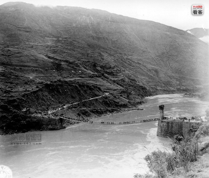 1944年5月11日，中国远征军开始从惠通河渡河打响从中国向滇缅反攻的第一枪。图为1944年7月17日，中国民工通过惠通桥向松山前线运输弹药。摄影师：乔治