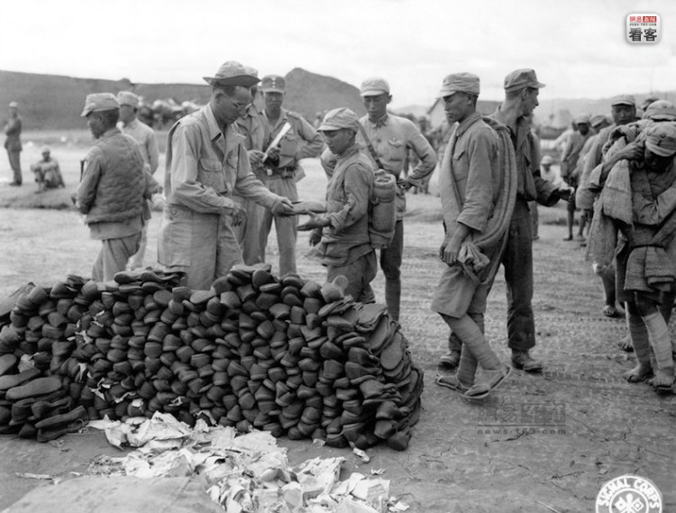 1944年10月1日，美军达维斯上等兵在向中国士兵分发胶鞋。美军通信兵（U