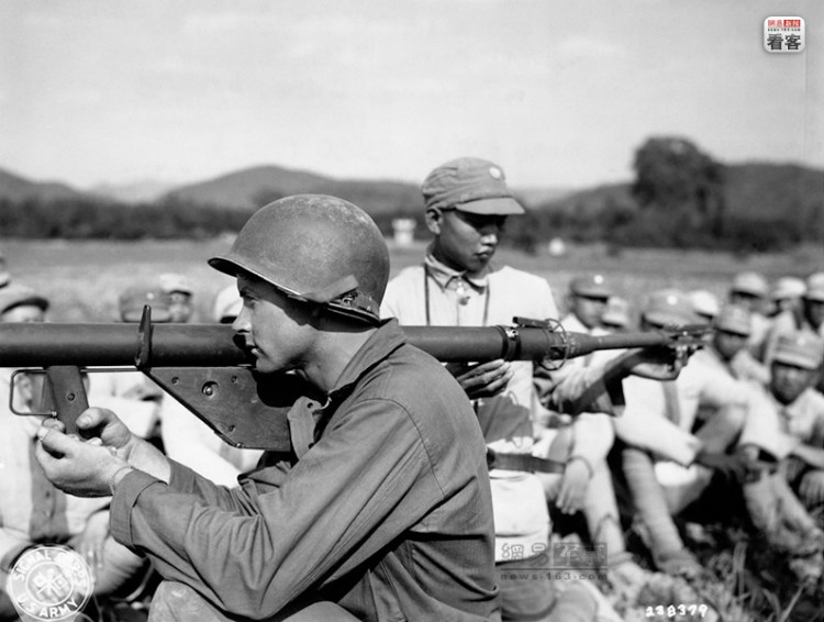 1945年4月18日，美军詹姆士上等兵在向中国第13军第276团的官兵们展示火箭筒的使用方法。美军通信兵（U
