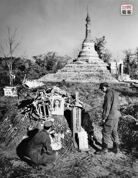 中美联军用砍刀在缅甸的崇山峻岭绵延600英里的密林中砍出一条路来向密支那发起进攻。经过11周残酷的密支那攻击战，中国驻印军和美军以伤亡6000多人的惨重代价，才艰难啃下了日军的所有堡垒。图为1945年2月10日，缅甸密支那一座佛塔前，2名美军士兵在一座泥土加草根堆成的坟前鲜花致敬，那里埋葬着他们的中国战友。摄影者：约翰