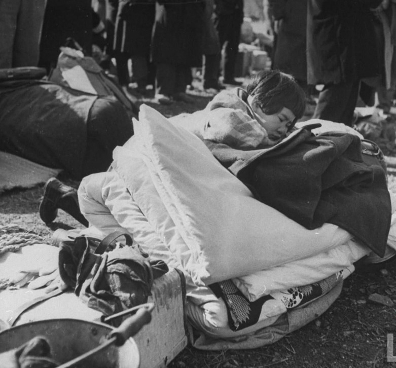 在被遣返前等待海关检查的日本女孩睡在一堆毛毯上。