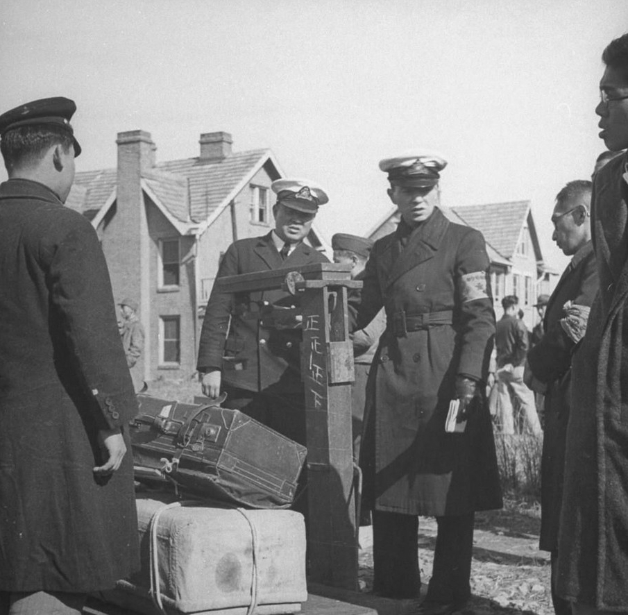 中国海关官员给被遣返日本人行李称重。