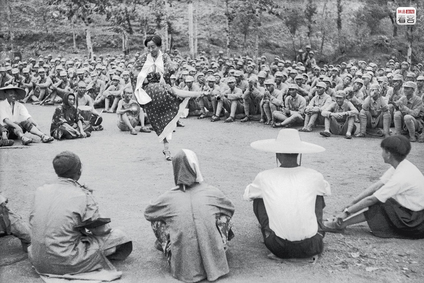 1939年7月，河北阜平陈庄，抗大二分校庆祝抗战两周年运动大会上，文工团在广场演出，吸引民众聚集观看。