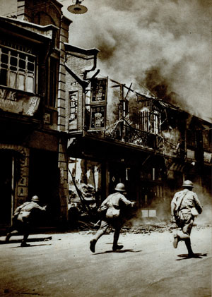 日军在硝烟弥漫的上海市街上搜索。