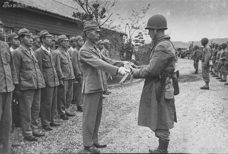 1945年9月，日本本州尾道。日本投降后，美国军官在接受一个海军基地，美国军官接受日本投降的军官指挥刀。
