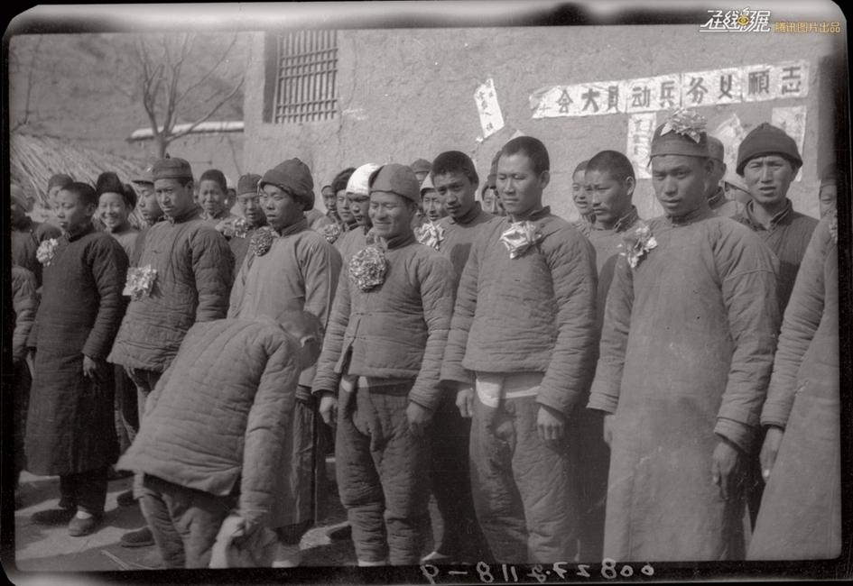 图为1942年，平山县儿童团向参加志愿义务兵的48名自卫队员致敬。摄影：罗光达。
