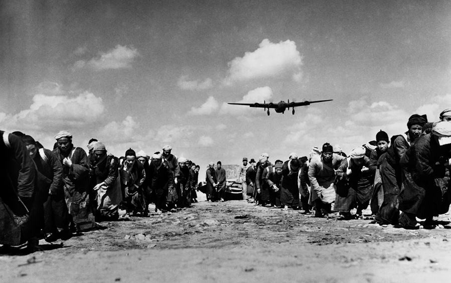 1944年3月31日照片所示体现了现代机械与传统民工的强烈对比， 表现这群民工奋力拖拉一个巨石碾子滚过跑道， 用血肉之躯铺筑通往民族解放之路。