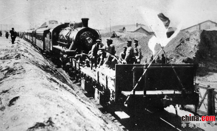 22-日军步兵第四十七联队乘火车向济南进发的情景。挂在火车车头前的是一节用于防御的车厢底座，底座最前面插有两面日本国旗。〔日本明信片《济南事变实况》〕