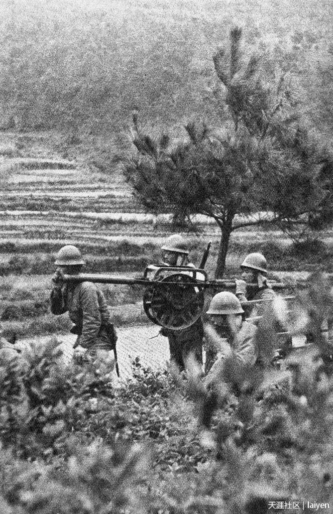 1940年1月31日，广西南宁北部山区，抬着炮车行军的日军金津部队士兵。