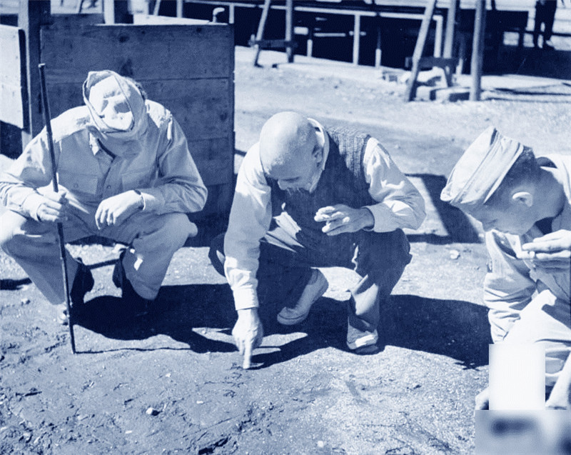 东条英机（C）与上校塞尔比，在沙子上演示怎么写他的名字。1945年 摄影师：乔治·Silk
