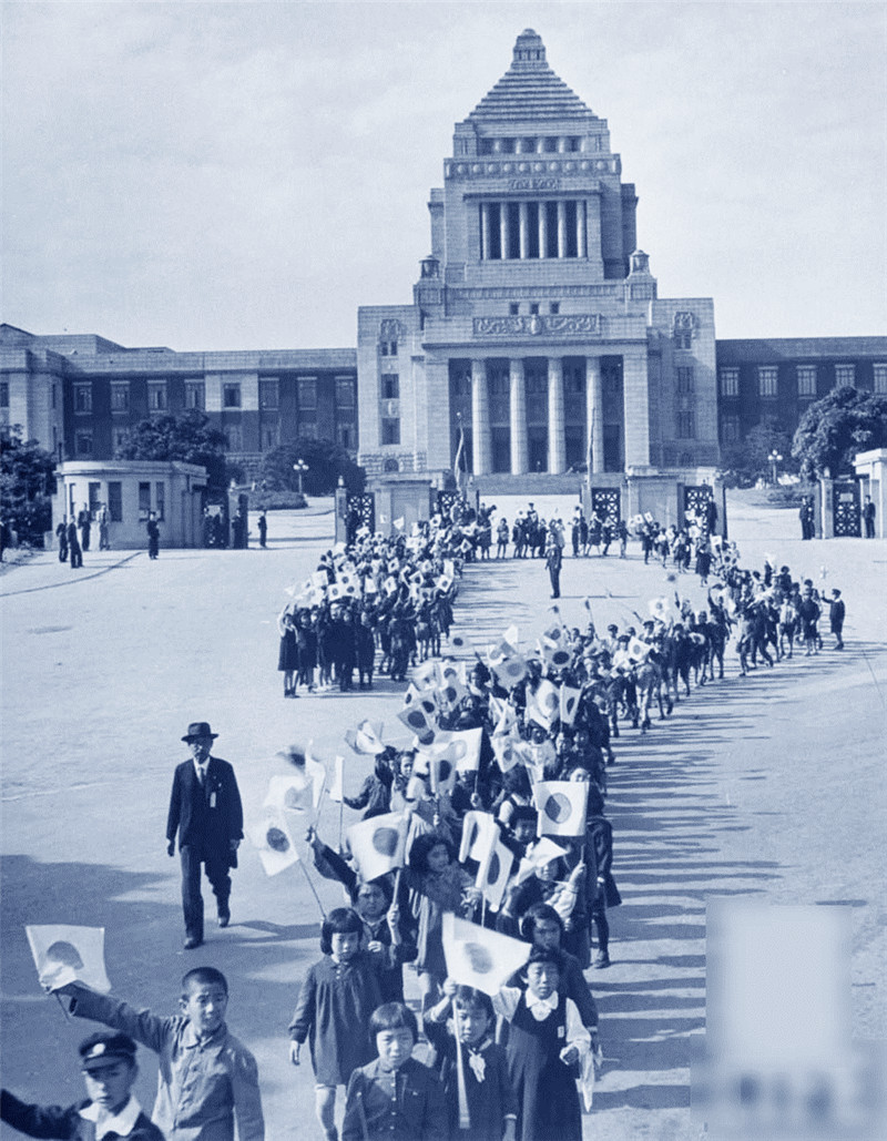 穿着盛装向国会建筑游行的学生们等待裕仁天皇的到来。地点：日本东京 1946年11月