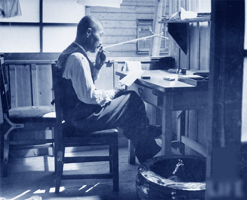 日本前陆军大臣东条英机吸烟香烟，坐在Omira监狱办公桌前，在那里因战争罪行他被关押的。地点：日本Omira 1945年10月 摄影师：乔治·Silk