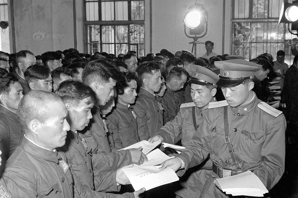 没有判刑的1017名战犯，被“从宽处理，免于起诉、即行释放”，分三批送回日本。1956年6月21日，中国最高人民检察院对在押第一批日本战犯宣布免予起诉决定书，这批战犯于当日释放。图为工作人员把免予起诉决定书发给战犯。