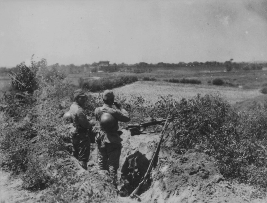 中国战场，日本士兵匍匐隐蔽在一座山坡上。