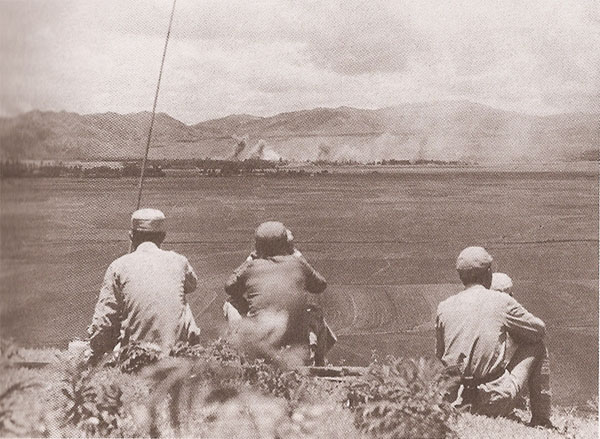 7月26日，美军出动大批B一25中型轰炸机轰炸腾冲，日方记录为五十七架次。图为在城东飞凤山高地观察轰炸效果的远征军军官。