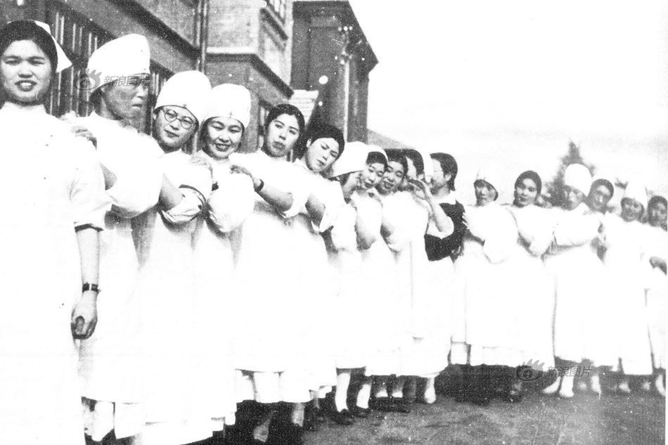 图为站在部队本部前的女护士。