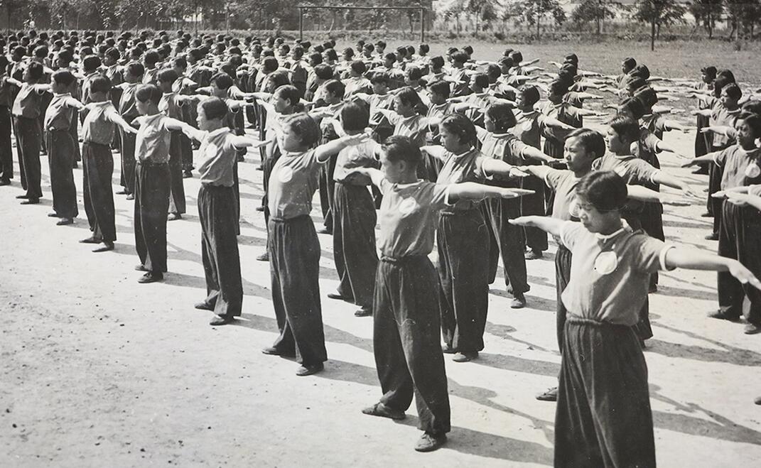 图为一群女学生在进行军训。