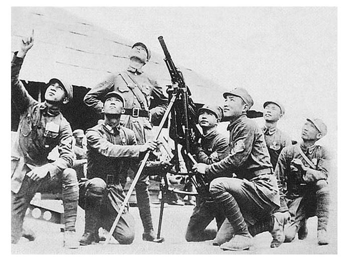 图为中国军队士兵正用高射机枪攻击日军轰炸机。