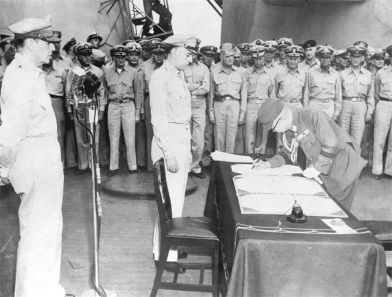 1945年9月2日，日本投降仪式在东京湾“密苏里”号战列舰上举行。图为日本陆军参谋总长梅津美治郎（前排右）在日本投降书上签字。新华社发